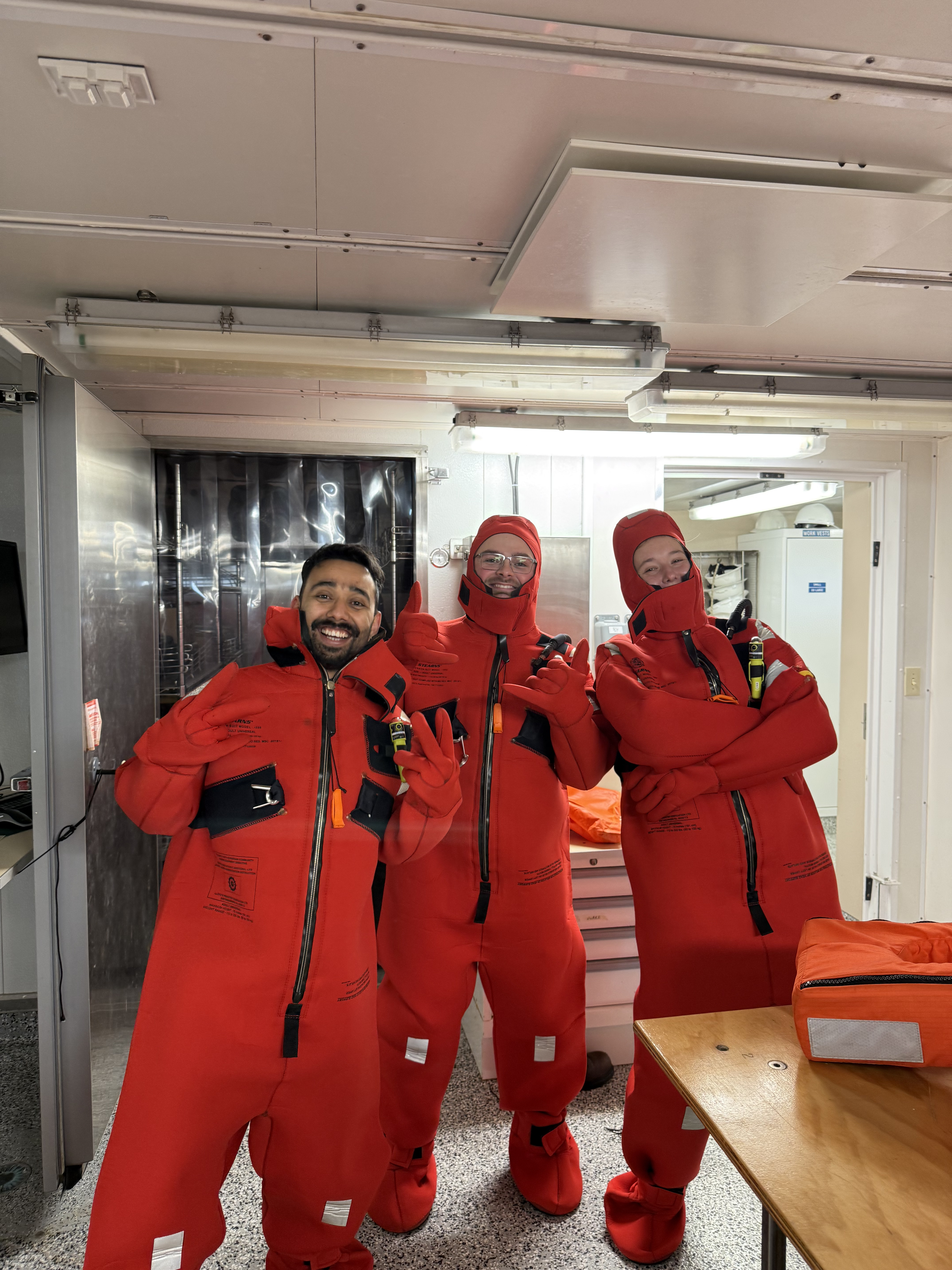 Students in immersion suits during shipboard safety training